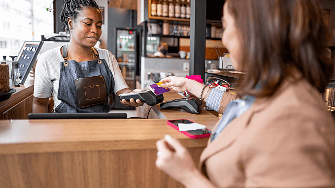 A customer making a payment over a counter